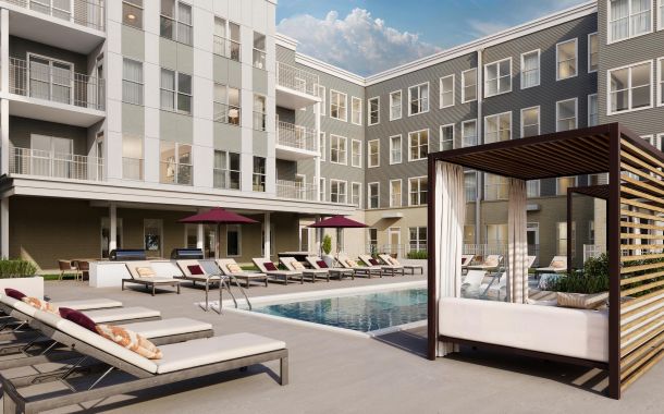 Modern apartment complex courtyard with a swimming pool, lounge chairs, cabana, and umbrellas.